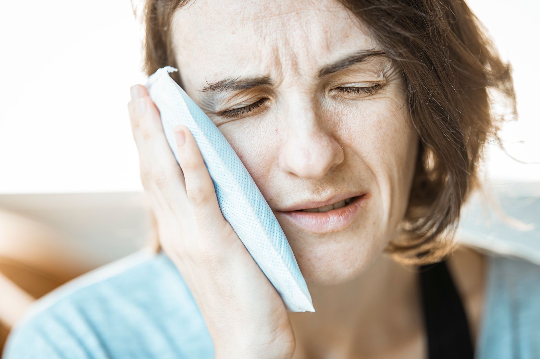 a woman putting cold compress on her face